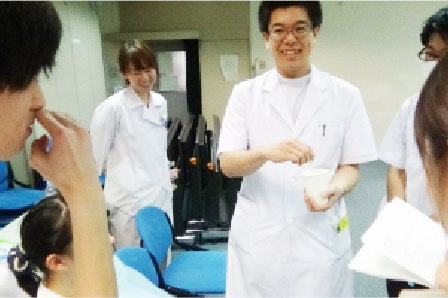 歯科医師役学生が水にとろみをつける方法を患者役学生に説明